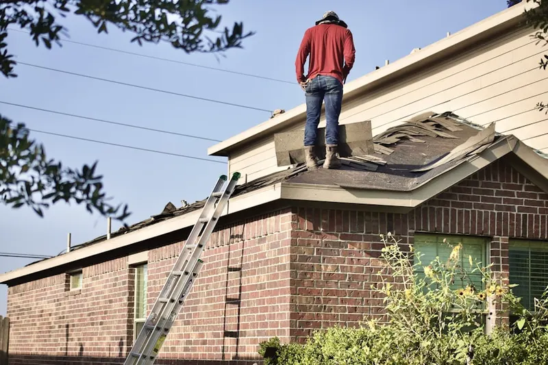 Professional roofer working on a residential roof in Del Ray